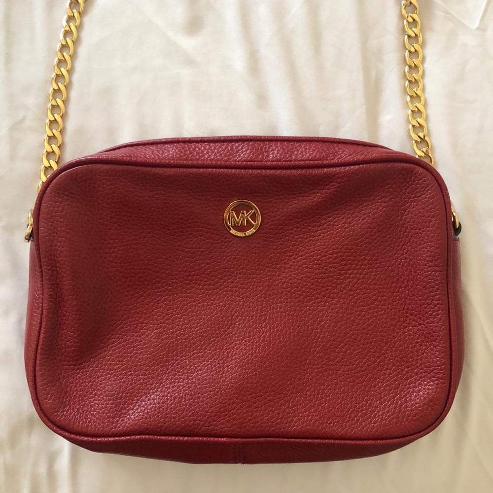I am selling a red Michael Kors crossbody bag.